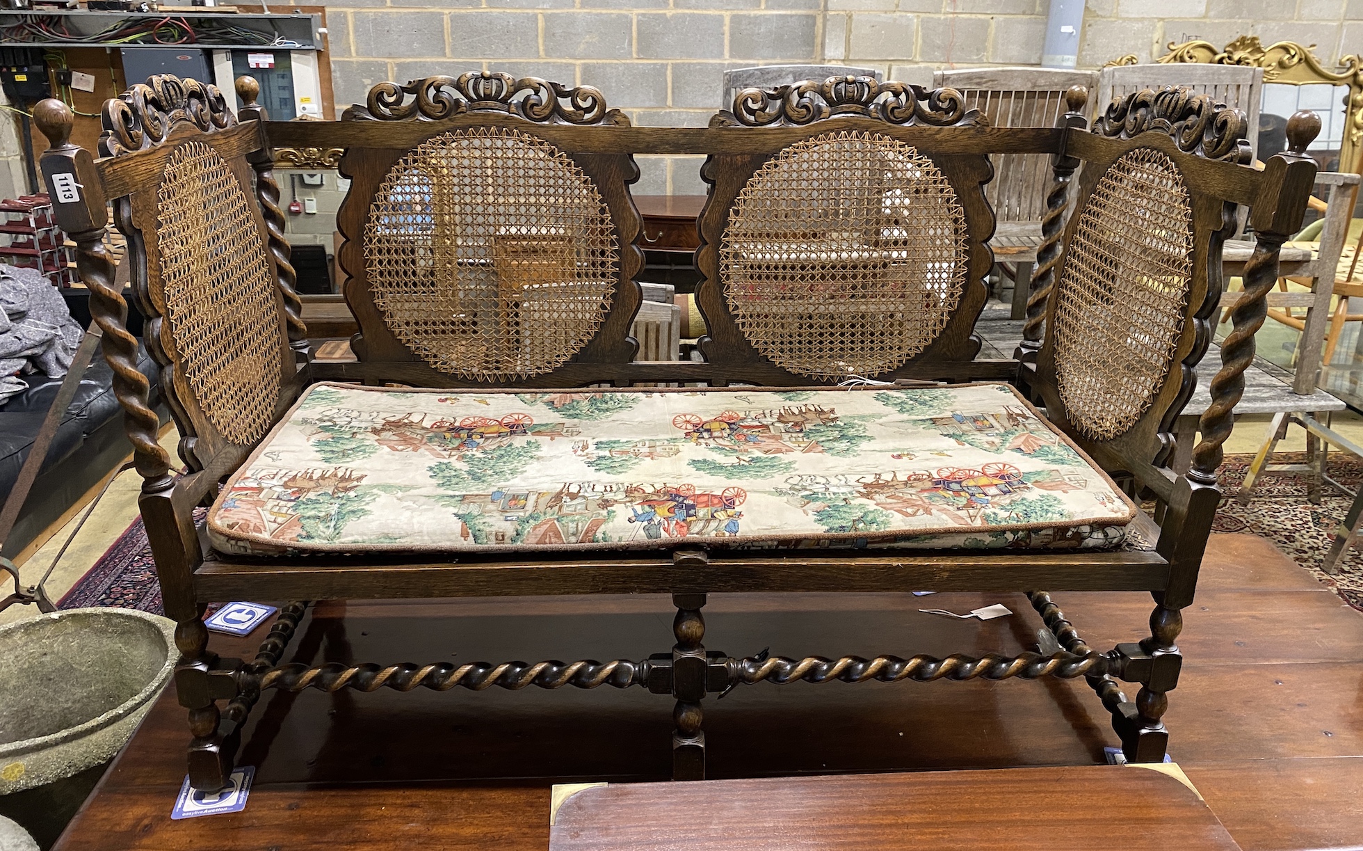 An early 20th century Jacobean revival caned oak settee, width 146cm, depth 65cm, height 95cm